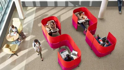 Puestos Steelcase Brody vistos desde arriba: butacas con paneles envolventes rojos y fucsias donde personas trabajan con notebooks.
