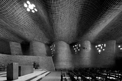 Interior de la Iglesia de Cristo Obrero, de Eladio Dieste: muros y techo de ladrillo que ondulan, con pequeñas aberturas de luz.