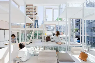 Casa Na de Sou Fujimoto: estructura blanca con plataformas a distintas alturas, libros y vidrio; varias personas sentadas y una subiendo.