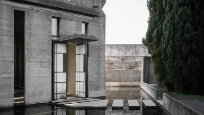 Tumba Brion de Carlo Scarpa: pabellón de hormigón con aberturas vidriadas sobre un estanque, pasos de piedra y cipreses al costado.