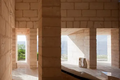 Can Lis de Utzon: muros y pilares de bloques de piedra arenisca con aberturas profundas que enmarcan el mar y dejan entrar el sol.