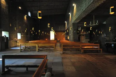 Interior de la iglesia de San Marcos de Sigurd Lewerentz: muros y bóvedas de ladrillo oscuro con juntas anchas, en penumbra.